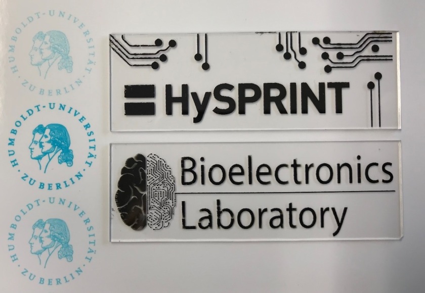 Logos of the collaborating partners fabricated by inkjet-printing, using a blue test ink and nanoparticle-based silver ink. - enlarged view